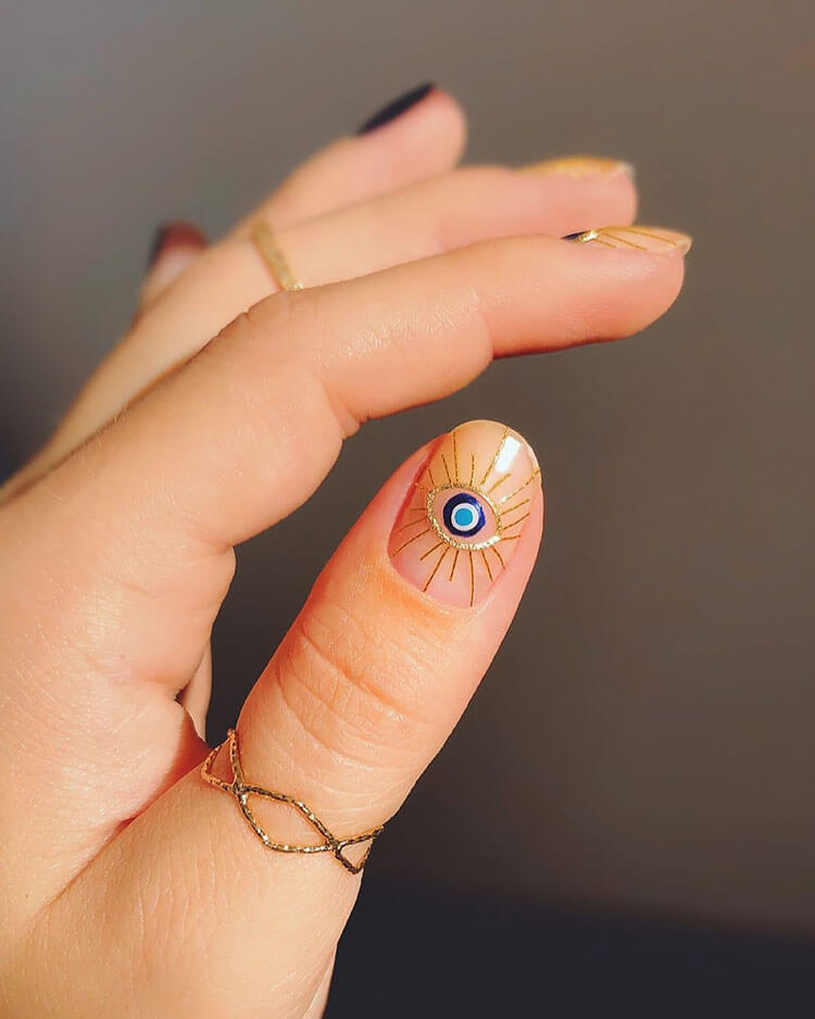 blue and gold evil eye nails